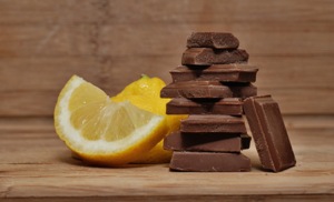 Chocolate pieces and lemon slices on wooden plate