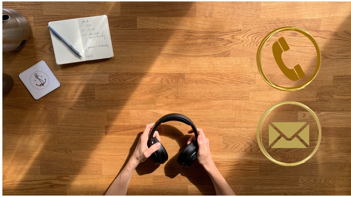 Schreibtischansicht mit Kopfhörern, Notizbuch und Kontaktmöglichkeiten für eine professionelle Voiceover-Zusammenarbeit.