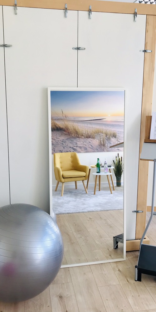 Hell gestalteter Coaching-Bereich im Tonstudio mit Sitzball, Spiegel und Stehpult für Sprechtraining und Regie.